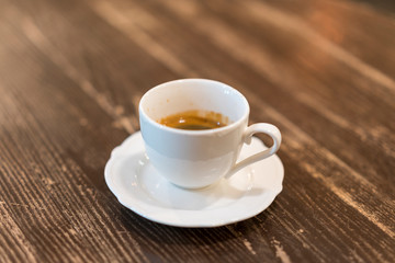 Cup of coffee with foam on wooden table, top view. A cup of coffee on wooden background