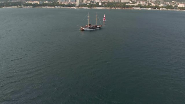 High-altitude two-masted high-altitude vessel near the coast of the sea. Aerial shot