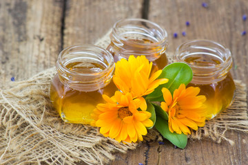 honey and flowers on wooden background