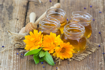 Obraz na płótnie Canvas honey and flowers on wooden background