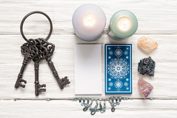 Blue tarot cards and key to the fate on white wooden table background. Clue to the fate concept.