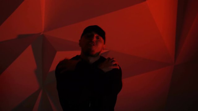 Rapper guy rap in front of the camera on a red background