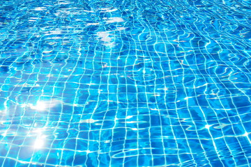 Top view of beautiful swimming pool with clear water and sunlight reflection on the surface in blue and turquoise color in the morning Relaxation on a day off, blurred focus of water motion background