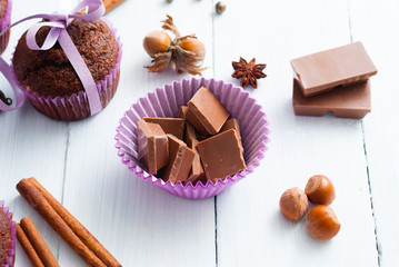 chocolate muffins with hazelnuts on white wooden