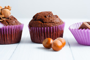 chocolate muffins with hazelnuts on white wooden