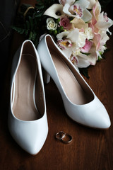 Wedding still life of flowers rings and shoes bride.