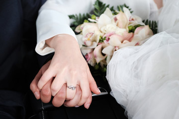 Hands of the bride and groom on the wedding day.