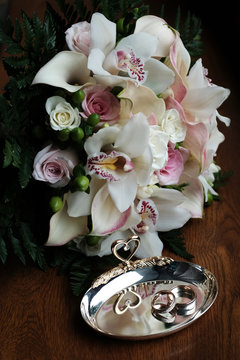 Wedding still life of rings and bride's bouquet.
