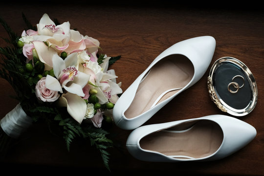 Wedding still life of flowers rings and shoes bride.