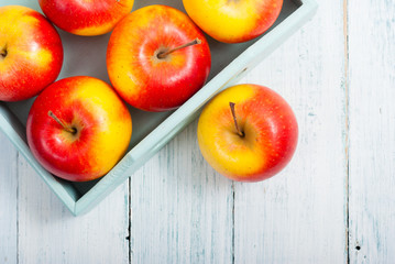 apples at blue tray, white wood table