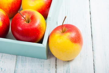 apples at blue tray, white wood table