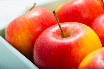 apples at blue tray, white wood table