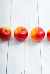 apple fruits in a row, white wooden table background