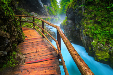 Noisy Radovna river in Vintgar gorge with wooden footbridge, Slovenia
