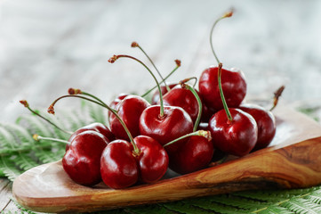 Dark red ripe large cherries on a wooden table, selective focus. Close up. Copy space