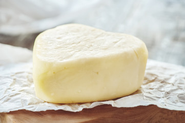 Suluguni cheese is a traditional cheese of the Caucasus. A piece of cheese in the shape of a heart. Suluguni is home-made