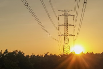 view of electric tower with sunset and yellow sky background.