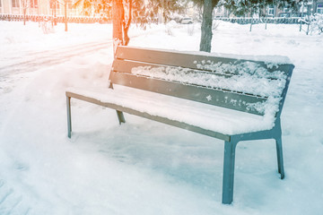 Garden bench in the Park in the winter snowfall. Seasonal phenomenon. Winter snow background