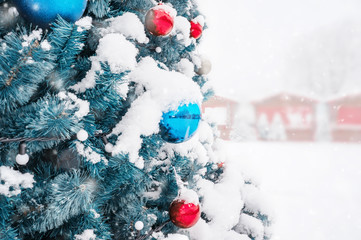 Fototapeta na wymiar Christmas decor Christmas tree under the snow on the street. Copy space. Selective focus