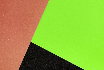 Fototapeta premium Multicolored sheets of paper on a dark leather background close up