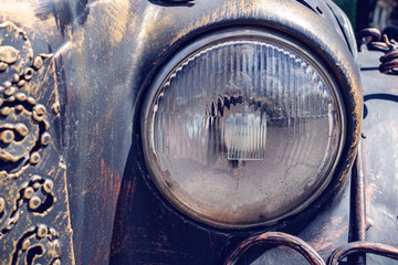 Gold metal vintage textured background with old glass round headlight and black forged pattern