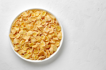 Corn flake in a bowl on white background, quick breakfast.