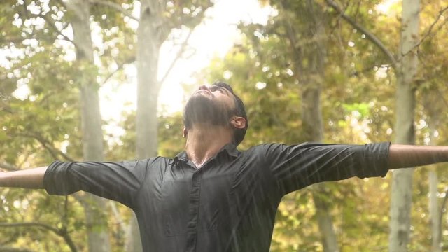 Young man  standing in the rain  And he feels the Fresh rain on his body