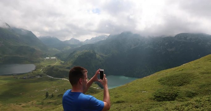 Traveler records landscape of Lake Ritom in the middle of the Swiss Alps for his social media accounts.