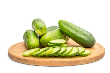 Cutted and whole cucumbers on cutting board..