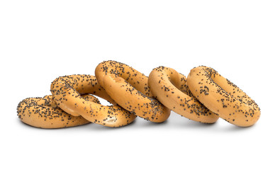 Row of dried bagels with poppy seeds on white.