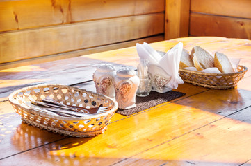 Table with cutlery in gazebo outdoors.