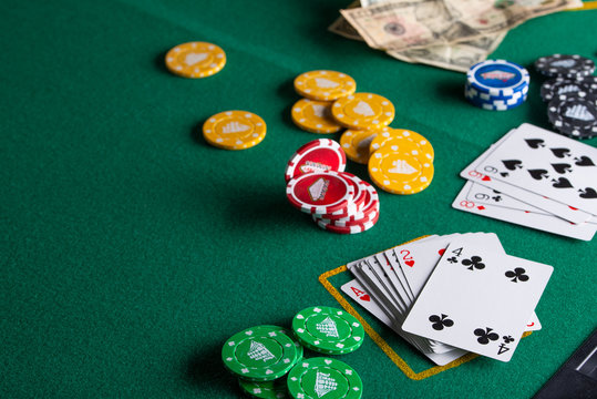 Casino, night life, online gambling business games. Chips, cards and dollars on a green table.