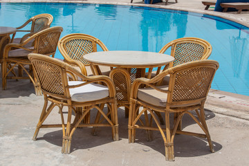 Rattan table and chairs in beach cafe near swimming pool next to the red sea in Sharm el Sheikh, Egypt