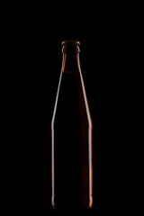 brown glass bottle of beer isolated on black background