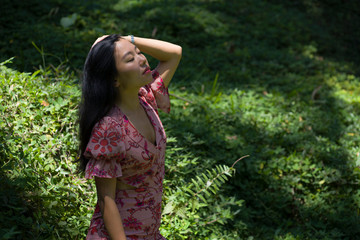 young beautiful and happy Asian Chinese woman in stylish dress enjoying adventure holiday trip exploring nature at tropical island jungle feeling fresh and relaxed