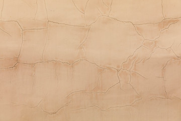 Background of beige plastered wall. Old paint cracked
