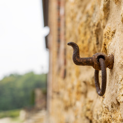 A rusty hook on a wall of limestone