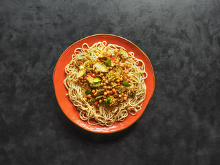 Noodle with romanesco cauliflower curry on a black table.
