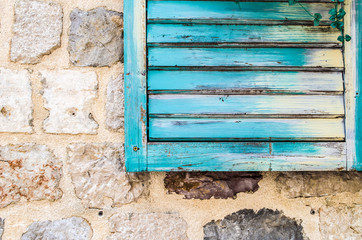 Old stone wall with closed shutters window