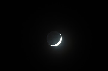 Moon with earth shine through a small telescope, 3 days old