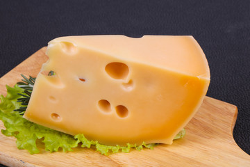 Maasdam cheese  in the board served salad leaves