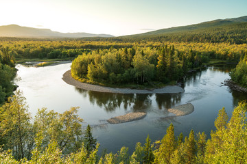 Fototapeta na wymiar A shallow river in the green hills of Jamtland, Sweden.