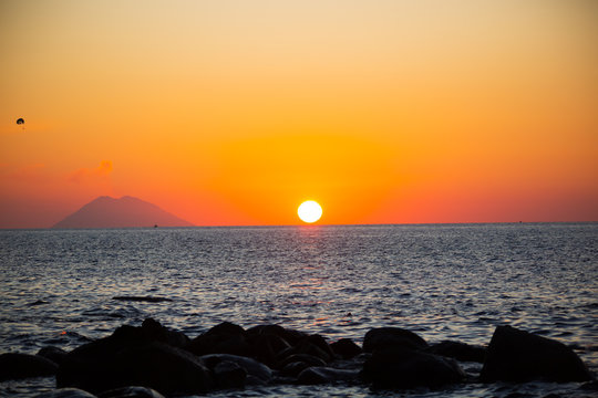 Stromboli and parachutist in the sunset