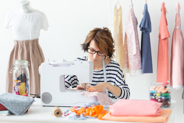 clothing designer, seamstress, people concept - clothing designer working in her studio