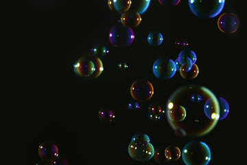 Beautiful soap bubbles colorful float on dark background