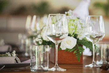 The beautiful arrangement on the wooden table, white roses and ceramic plates. Boho chic wedding table setting. 