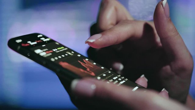 Stock market concept, trading online, trader working with smartphone on stockmarket trading floor. Woman touching screen, browse foreign exchange market data, chart