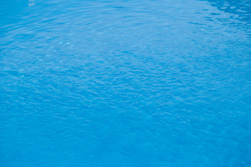 Fototapeta na wymiar Blurred water texture in summer pool close up.