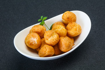 Sweet tasty profiteroles heap in the bowl