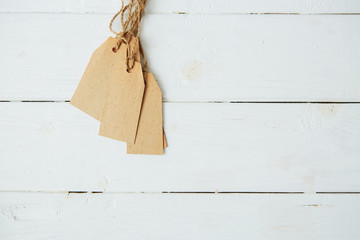 Label tag blank on wooden One paper blank tags with rope on wooden background.